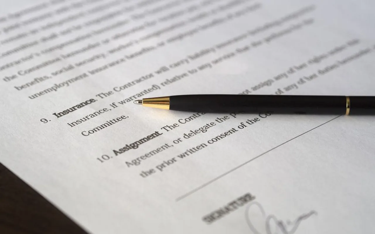 Couple relisant un contrat décès invalidité avec documents et stylo sur la table
